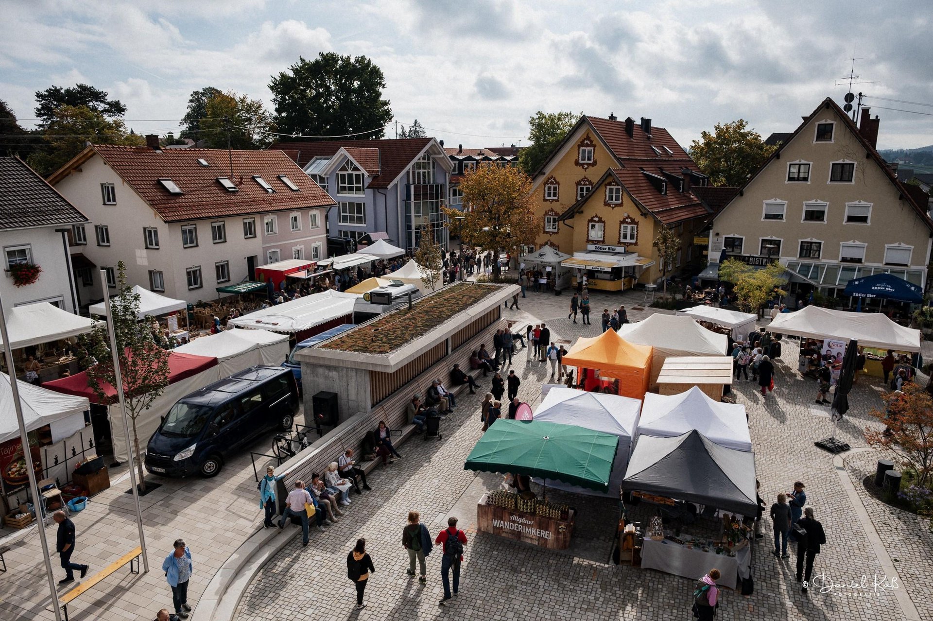 Buntes Treiben auf dem Alternativen Markt: Zahlreiche Marktstände säumen den neu gestalteten Marktplatz in Altusried, während Besucherinnen und Besucher das vielfältige Angebot entdecken und genießen.